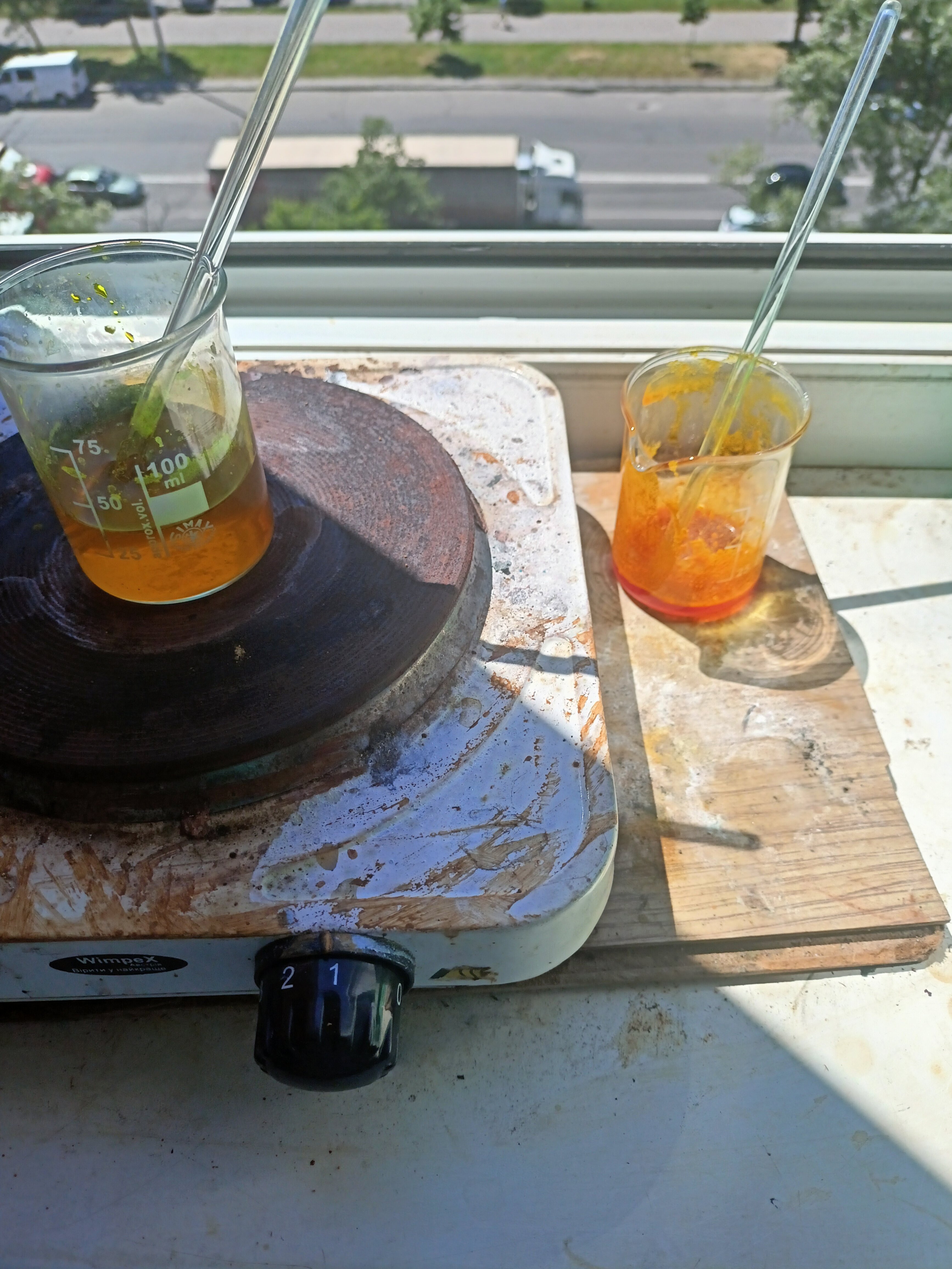 Two beakers, one on a hotplate, one filled with an orange solution of Sodium Picrate, the other with a darker solution of sodium sulfide