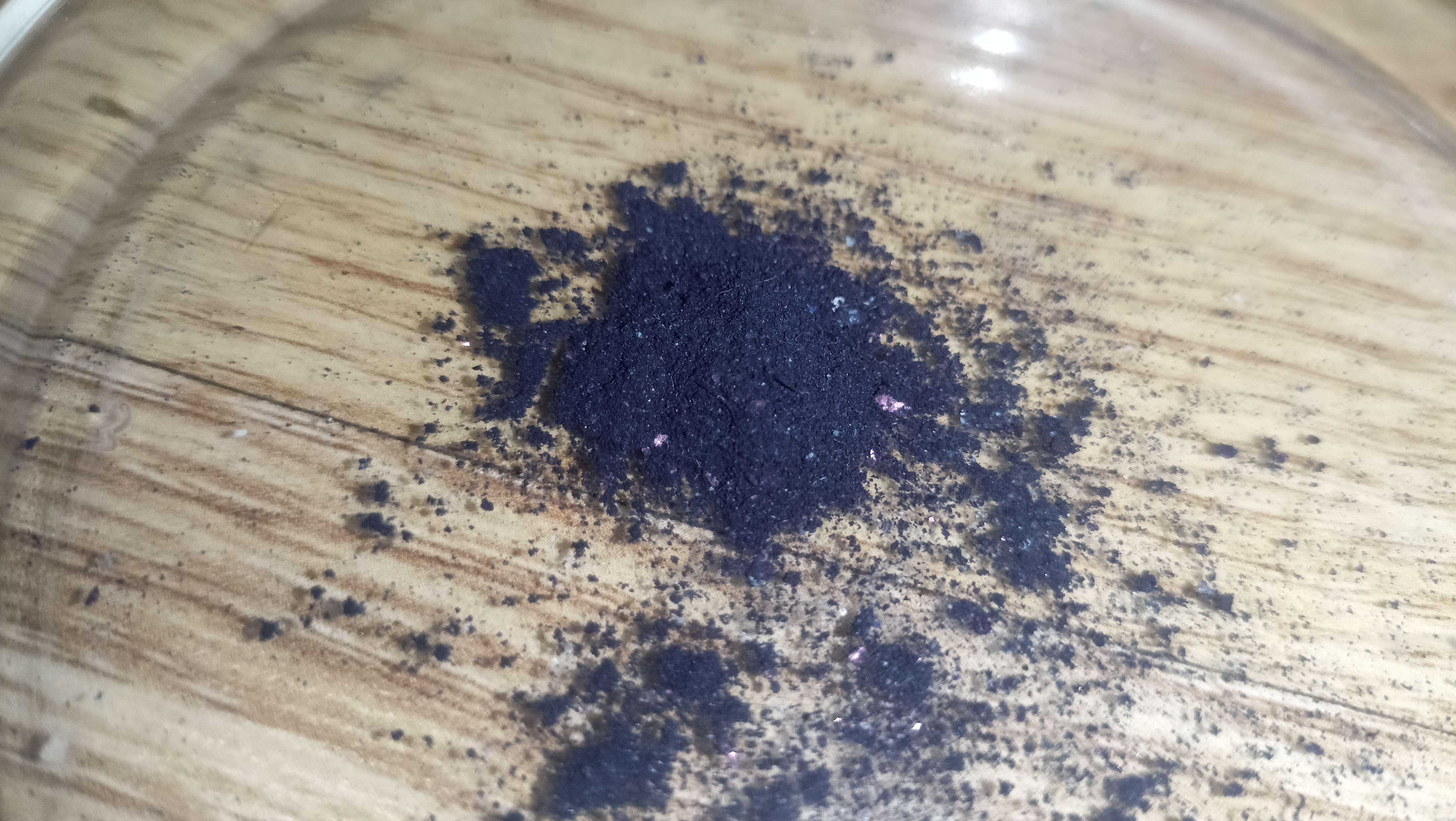 A very very dark blue powder in a dish