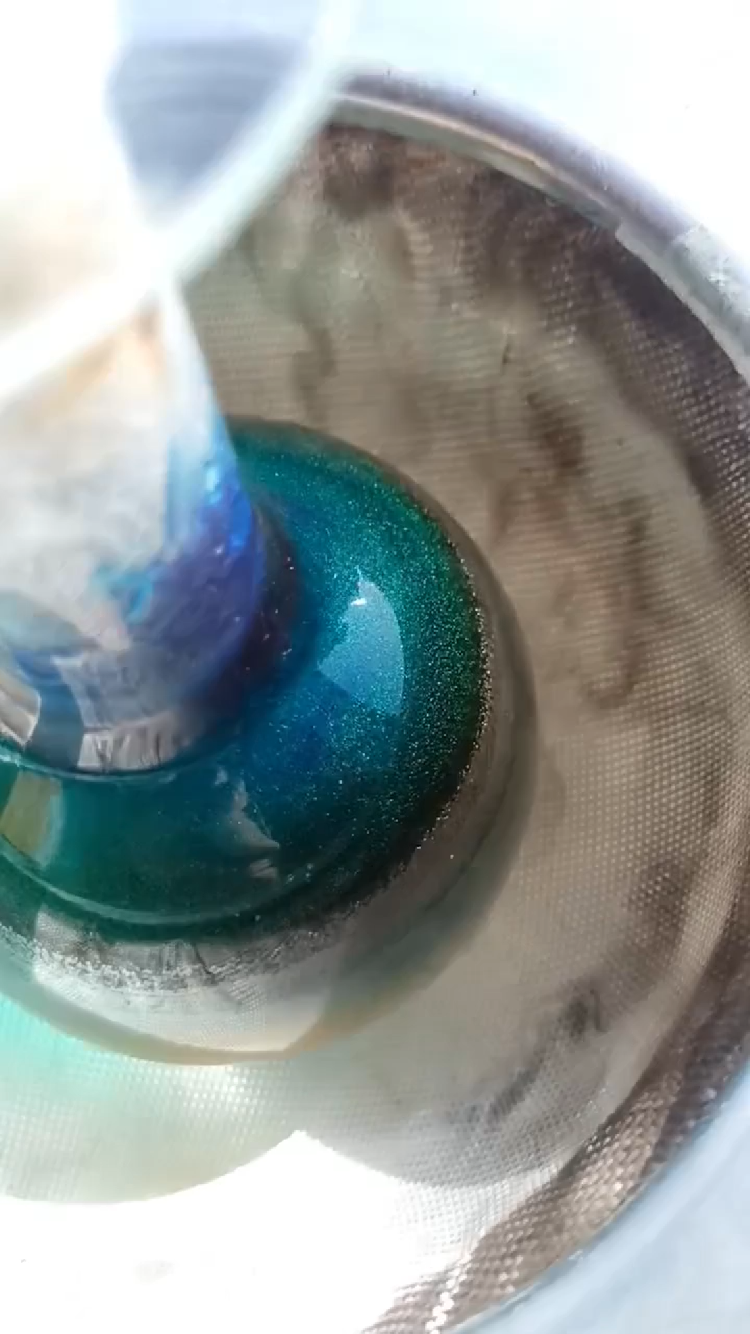 Shiny greenish-blue crystals sublimating on the top of a round bottom flask